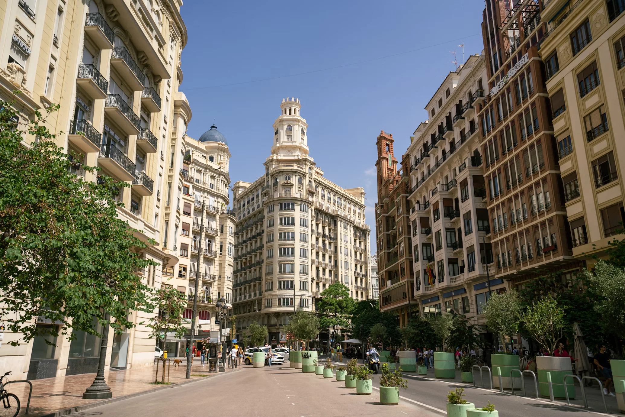 a street in Plaza de Ayuntamiento in Valencia with buildings on each side during the daytime.