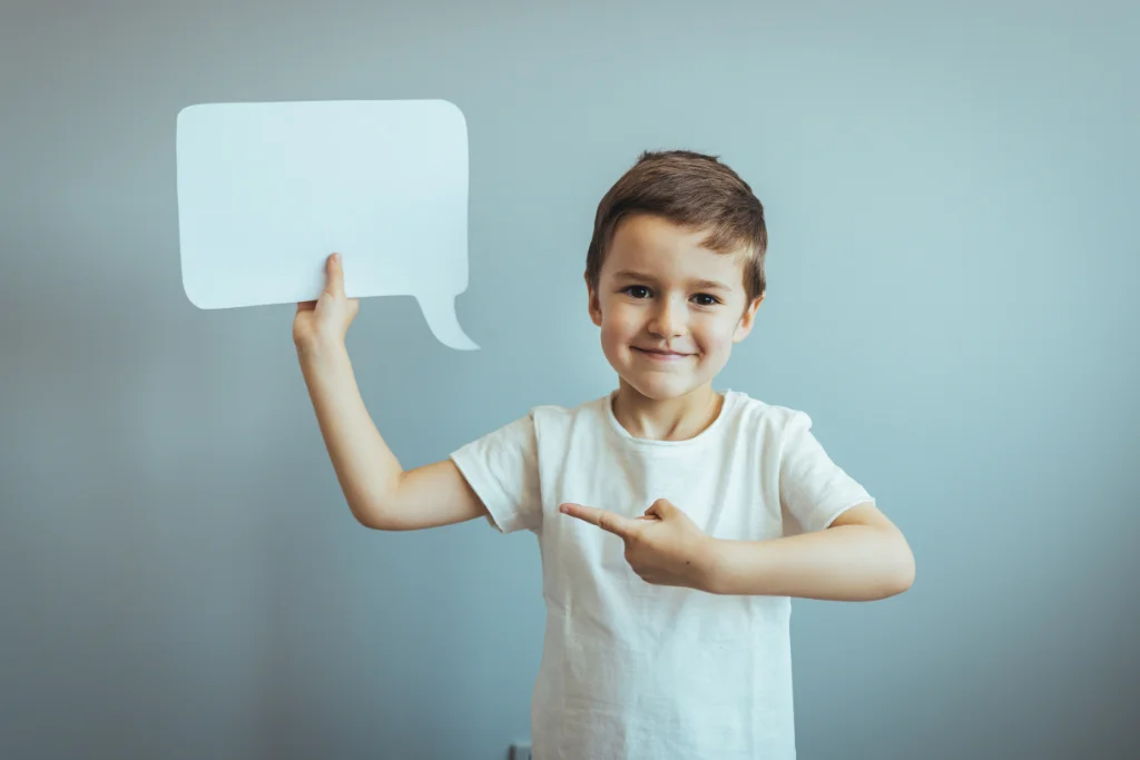 smiling-child-pointing-at-speech-bubble-representing-communication-skills-in-english-lessons