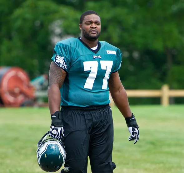 Demetress Bell #77 in Philadelphia Eagles practice jersey holding helmet during 2012 training session