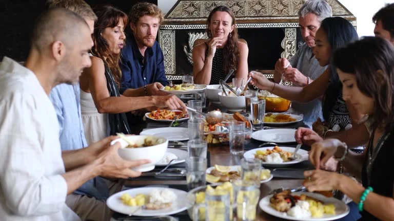 Moroccan family gathering around table sharing kouskousi meal