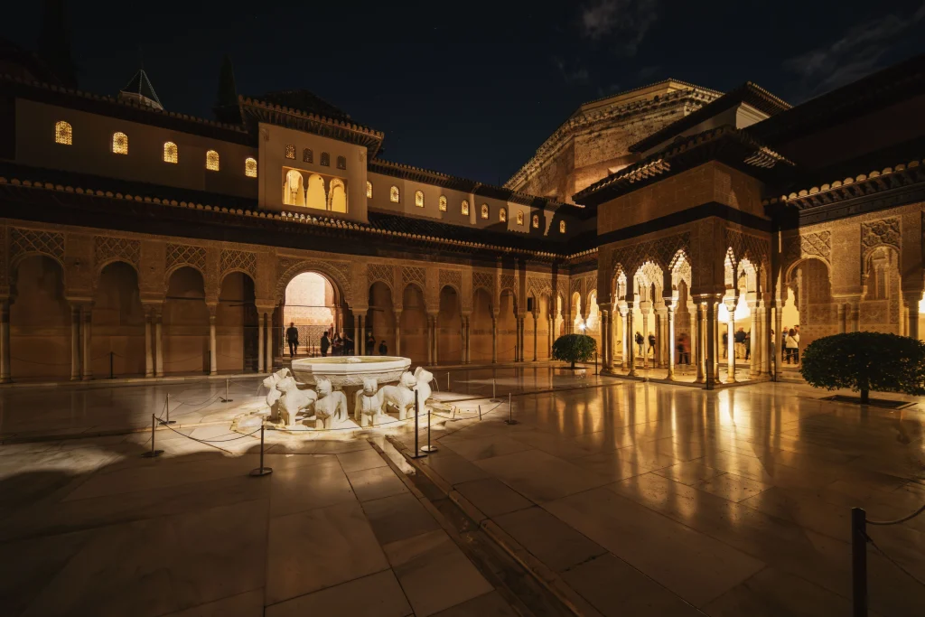 Granada's Alhambra complex lit up against the evening sky in Spain