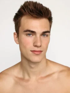 Studio headshot of American model Zach Cox with styled brown hair and blue eyes