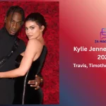 Kylie Jenner and ex-partner Travis Scott in matching black outfits posing together against a red rose wall